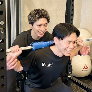 トレーナーが器具を使って指導する様子