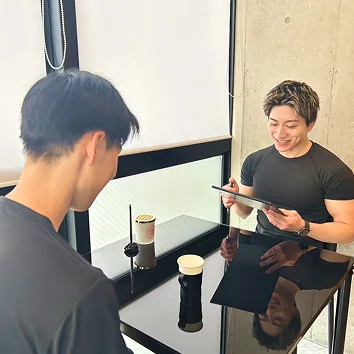 カウンターでプランを説明するトレーナーとお客様