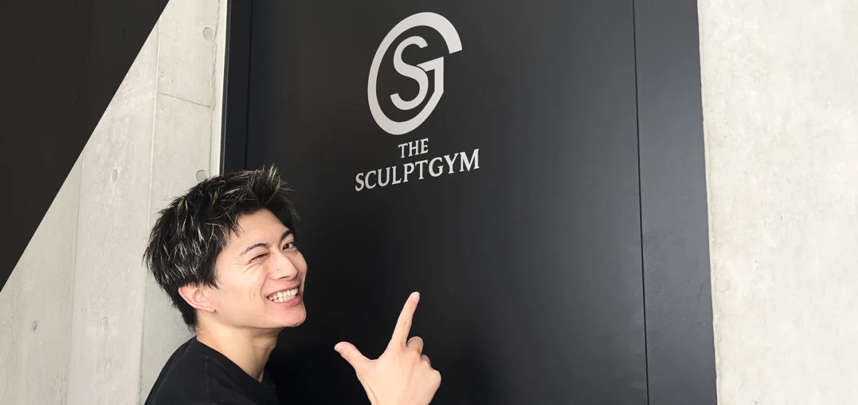 THE SCULPT GYMのロゴを指さす男性